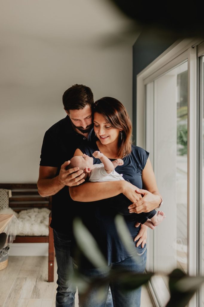 portrait de famille avec bébé dans les bras lors d'une séance photo à domicile à Biarritz