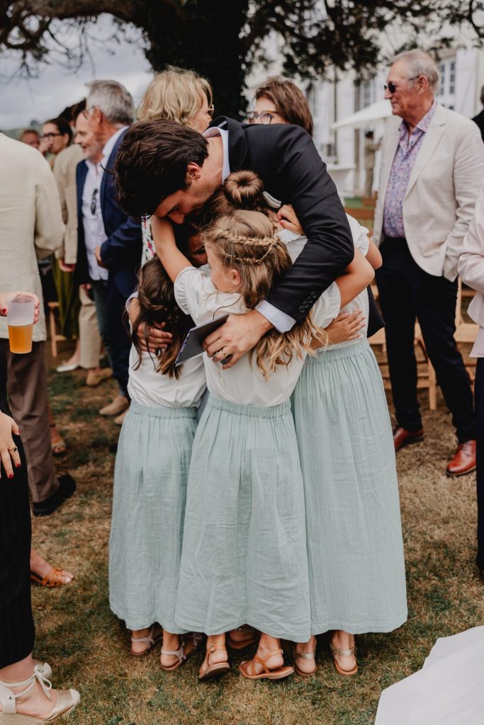 le marié enlace les demoiselles d'honneur lors du son mariage à la maison belzunce au pays basque, photo douce et élégante