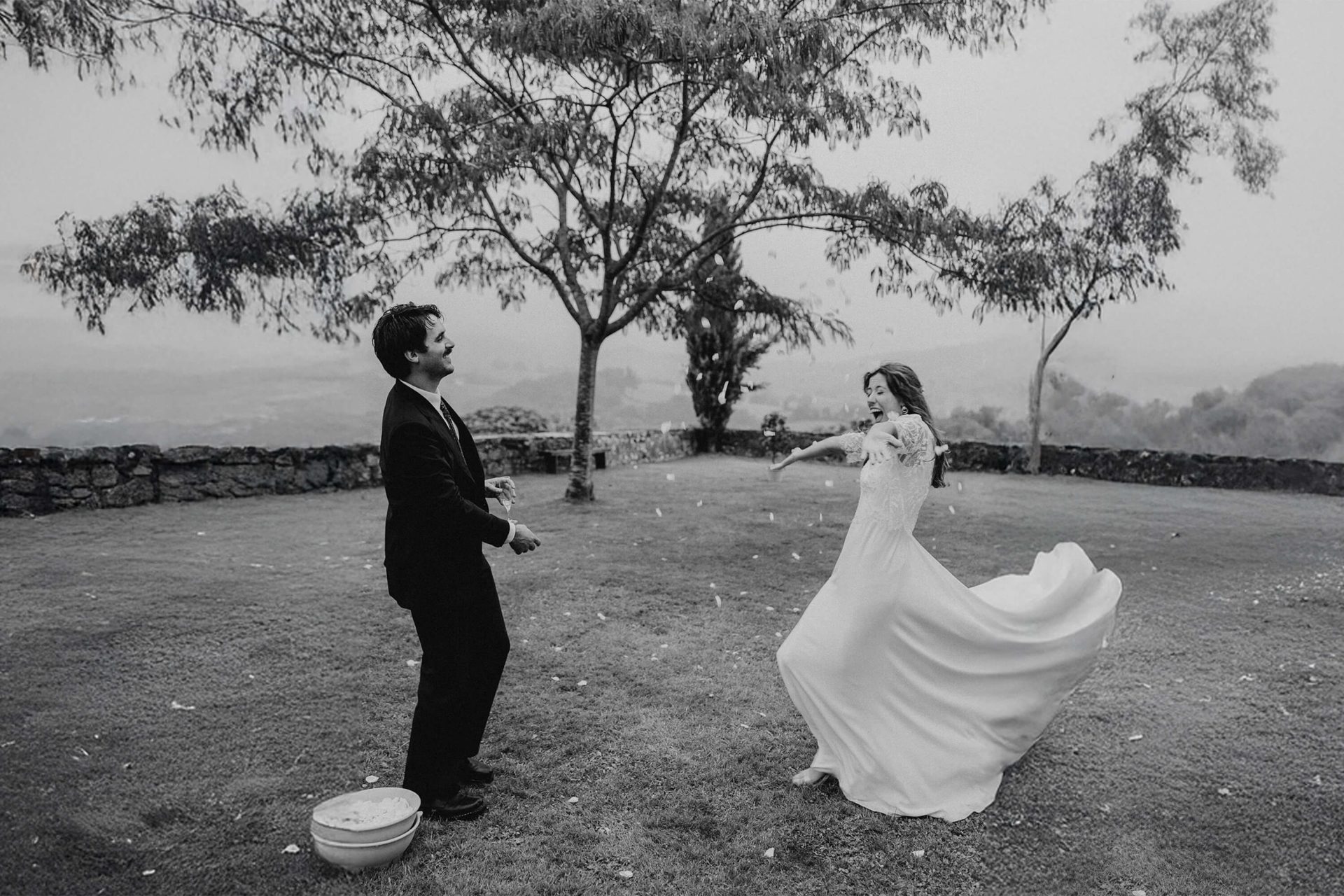 couple de mariés s'amuse avec des pétales de fleurs lors d'une séance photo de couple pendant leur mariage à Biarritz à la maison Belzunce